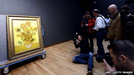 Photographers shoot pictures of the famous painting Sunflowers by Vincent Van Gogh