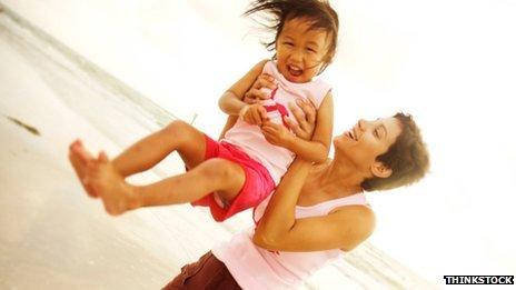 Woman holding young child on beach