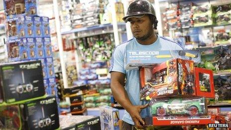 A man buys discounted toys in Caracas (15 Nov 2013)