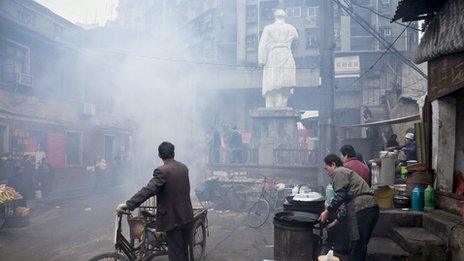 People celebrate Mao's anniversary by burning paper money underneath his statue, Huangshi City, Hubei Province, 26 December 2007. The statue was built in 1967.