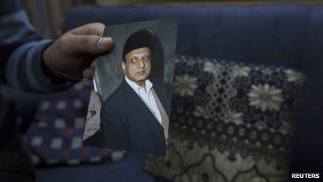 A photograph of Masood Ahmad is held by his nephew at his house in Lahore December 10, 2013