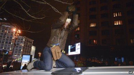 In this file photo from 25 November, 2013, Ukrainian journalist Tetyana Chornovol beats the roof of a police minivan with a stone during a pro-European Union rally in Kiev