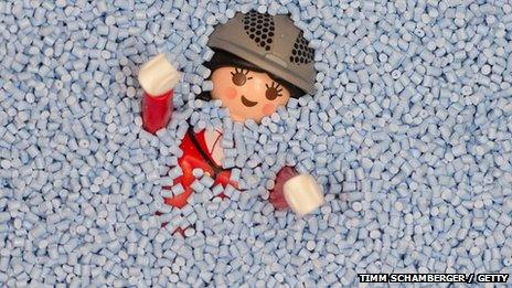 Plastic Playmobil toy character covered in plastic granules