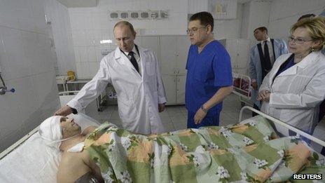 Vladimir Putin (L) meets a survivor of one of the recent bombings at a local hospital in Volgograd January 1, 2014.