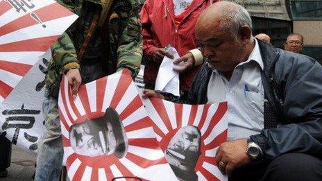 Chinese Protesters burn Japanese "rising sun" naval flags outside the Japanese Embassy in Hong Kong on December 13, 2013.