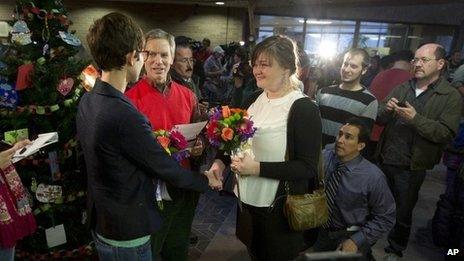 Natalie Dicou, left, and Nicole Christensen, right, are married by Salt Lake City Mayor Ralph Becker, middle, in the lobby of the Salt Lake County Clerk's Office in Salt Lake City 20 December 2013