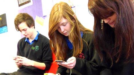 Louis Eastwood, Rachel Mailes and Tash Bagley looking at phones