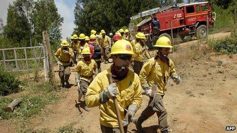 Workers from Chile's National Forestry Corporation rush to battle a forest fire at Tome town on 7 January, 2014