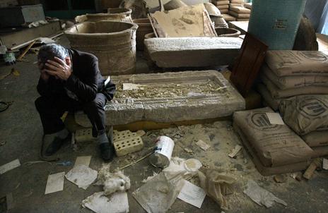 An Iraqi Museum official sits amid looted wreckage just after the 2003 invasion