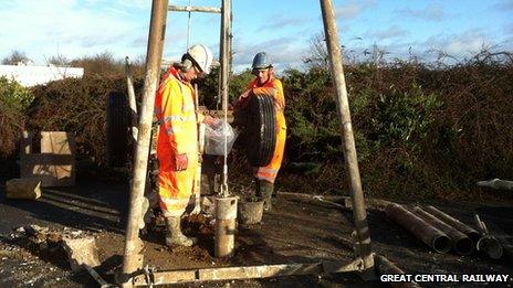 Workmen drilling boreholes to test the ground conditions ready for a bridge