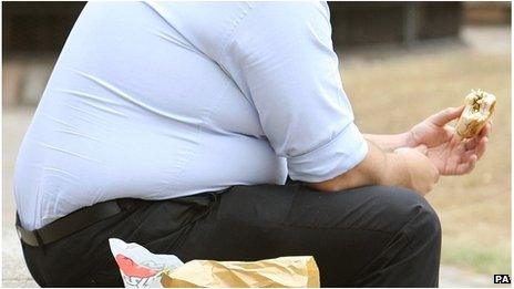 Overweight man eating fast food