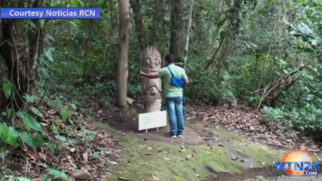 A visitor touches the cardboard statue