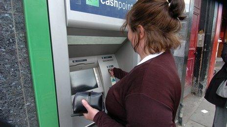 Woman removing money from ATM