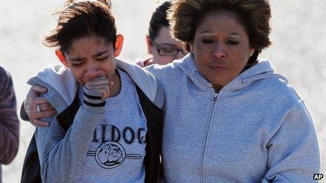 A student, left, is hugged after being united with families following a shooting at Berrendo Middle School, Roswell, New Mexico 14 Janury 2014