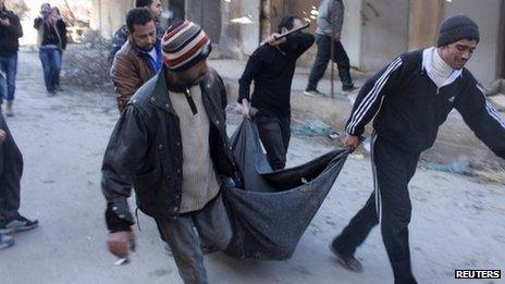 The body of a man believed to have been executed by Islamist State in Iraq and the Levant (ISIS) is carried through Aleppo (8 January 2014)