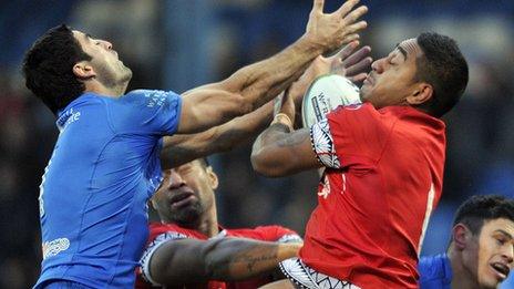 Tonga's Nesiasi Mataitonga (r) and Italy's Anthony Minichiello challenge for the ball