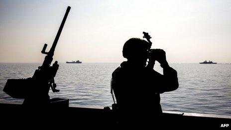 A member of the Norwegian naval forces on the deck of the frigate Helge Ingstad as the ship secures the port of the Syrian city of Lakakia during an operation to remove chemical agents from Syria