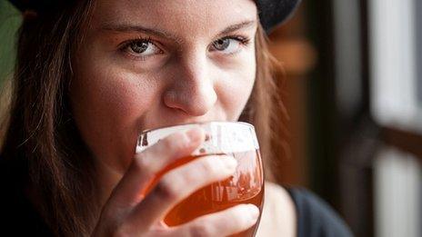 A woman drinking a pint of beer