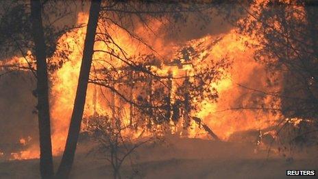 A fast-moving California wildfire, so-called the "Colby Fire," burns nearby homes, in the hills of Glendora 16 January 2014