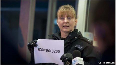 Supt Liz McAinsh holds up the Child Rescue Alert system telephone number