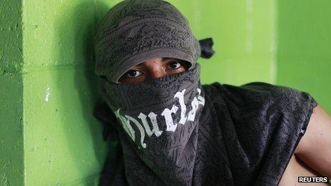 A member of the Barrio 18 gang poses for a photograph at a bakery in a neighbourhood in Ilopango, El Salvador