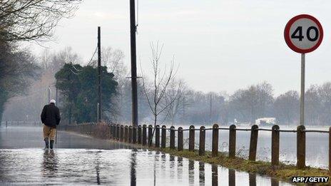 Man walking on flooded road in Yalding