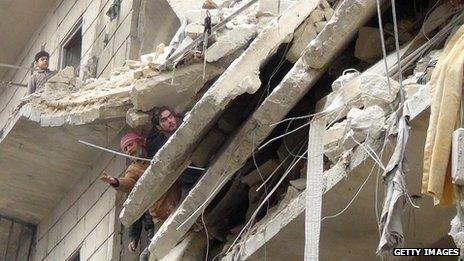Syrians inspect the damage following a reported government airstrike on the northern Syrian city of Aleppo on 23 January 2014.
