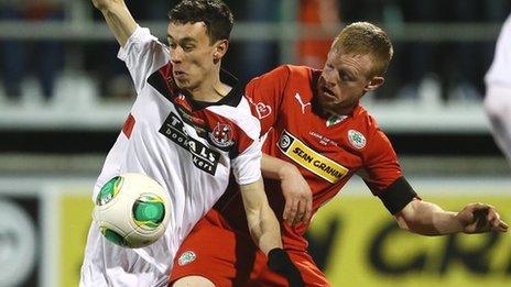 Crusaders winger Paul Heatley gets a nudge from George McMullan