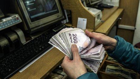 Woman counting lira at an exchange counter