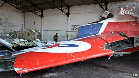 A file picture taken on 16 September 2009 shows a Comoran soldier looking at aircraft remains recovered from the Indian Ocean in a disused airport hangar in Moroni, Comoros.