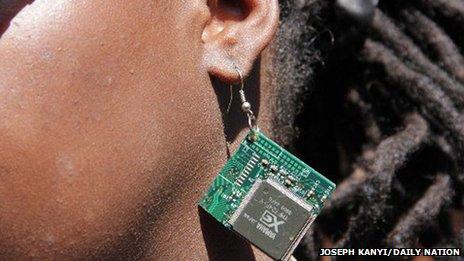 A woman wears an ear ring made out of a computer chip