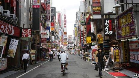 People walk along a street in a nightlife district in Tokyo on 4 September 2013.