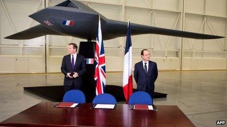 David Cameron and Francois Hollande stand beneath a model of an unmanned aircraft