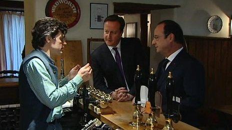 David Cameron and Francois Hollande speak to the landlord of The Swan Inn