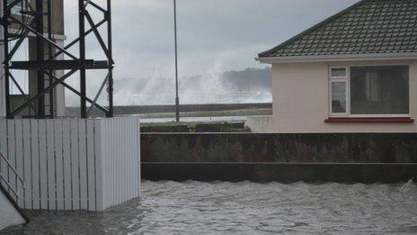 Flooded carpark with waves crashing in background