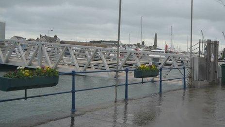 The water breaching the barrier on the pier