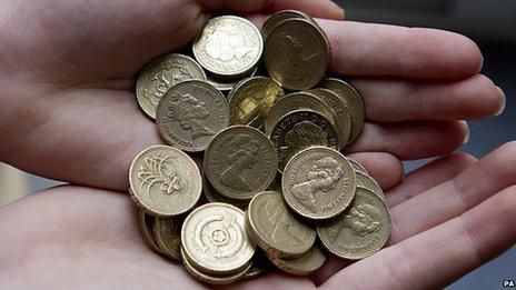 A person holds pound coins