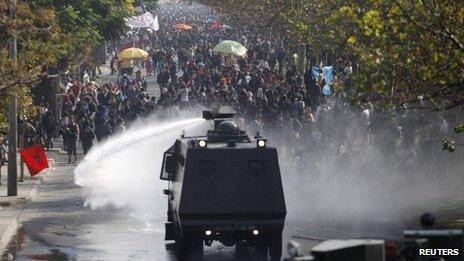 A police water cannon releases a jet of water on student protesters in Chile, April 2013