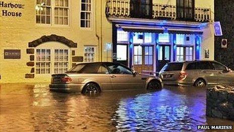 The front of Harbour house with two parked cars out the front