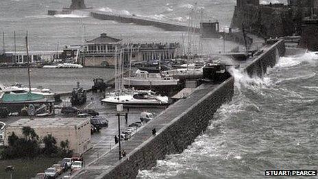 Waves break over the wall at St Peter Port