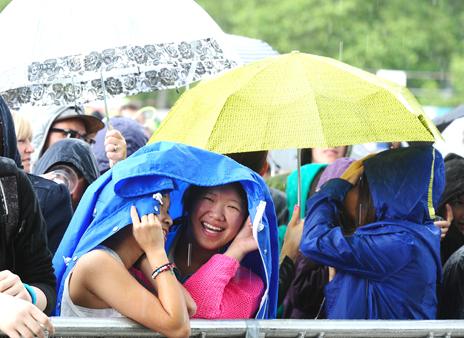 Members of the crowd during the rain at the Barclaycard Wireless Festival 2012 at Hyde Park in London.