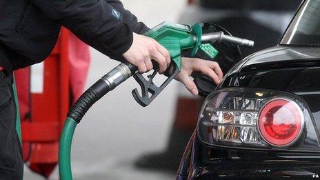 A person using petrol pump at a petrol station