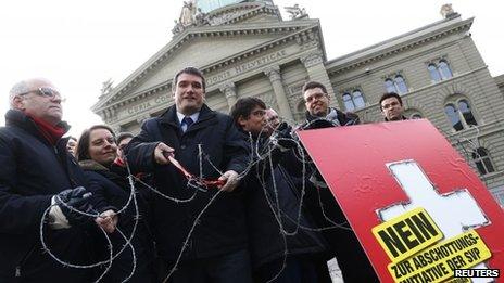 A Swiss Socialist Party member and others cut a symbolic barbed wire fence, as part of their campaign to re-impose quotas on migrants