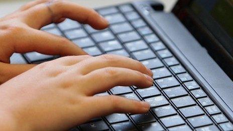 Fingers typing on a laptop