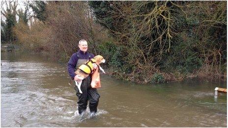 Darren Fuller, 48, takes his dog to the vet through flood water in Shepperton