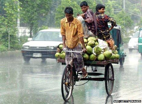 An Indian man riding a rickshaw in a monsoon