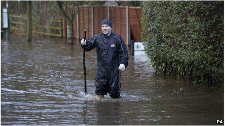 Dean Garland makes his way through flood water in Egham