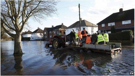 Tractor and trailer in flooded street in Egham