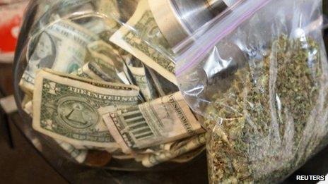 A bag of marijuana being prepared for sale sits next to a money jar in Northglenn, Colorado, on 31 December 2013