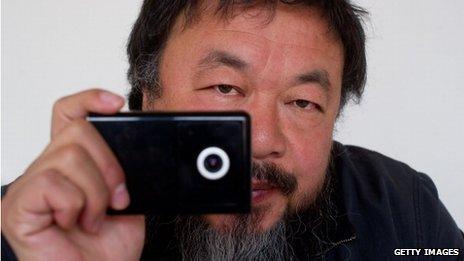 Ai Weiwei, holding a webcam